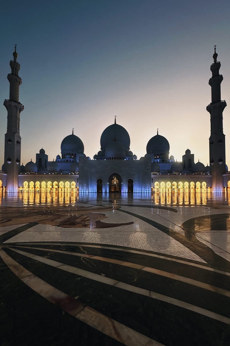 Grand architecture glowing at dusk under a deep blue sky