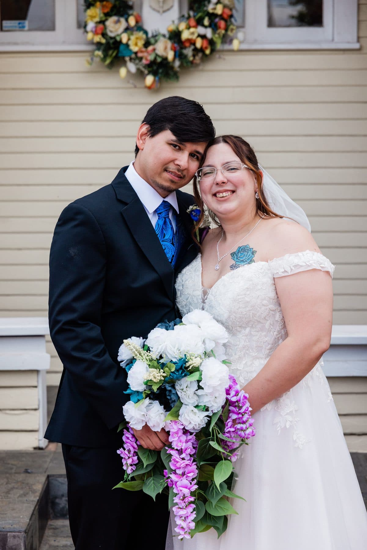 The newlyweds smiling together just after the ceremony, bouquet in hand.