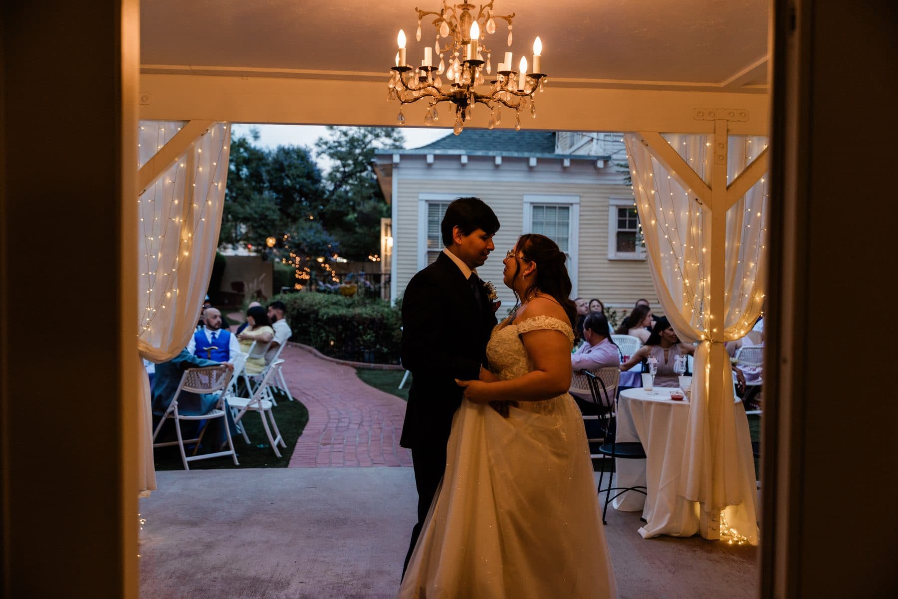 A wide view of the first dance, framed in a lit doorway.