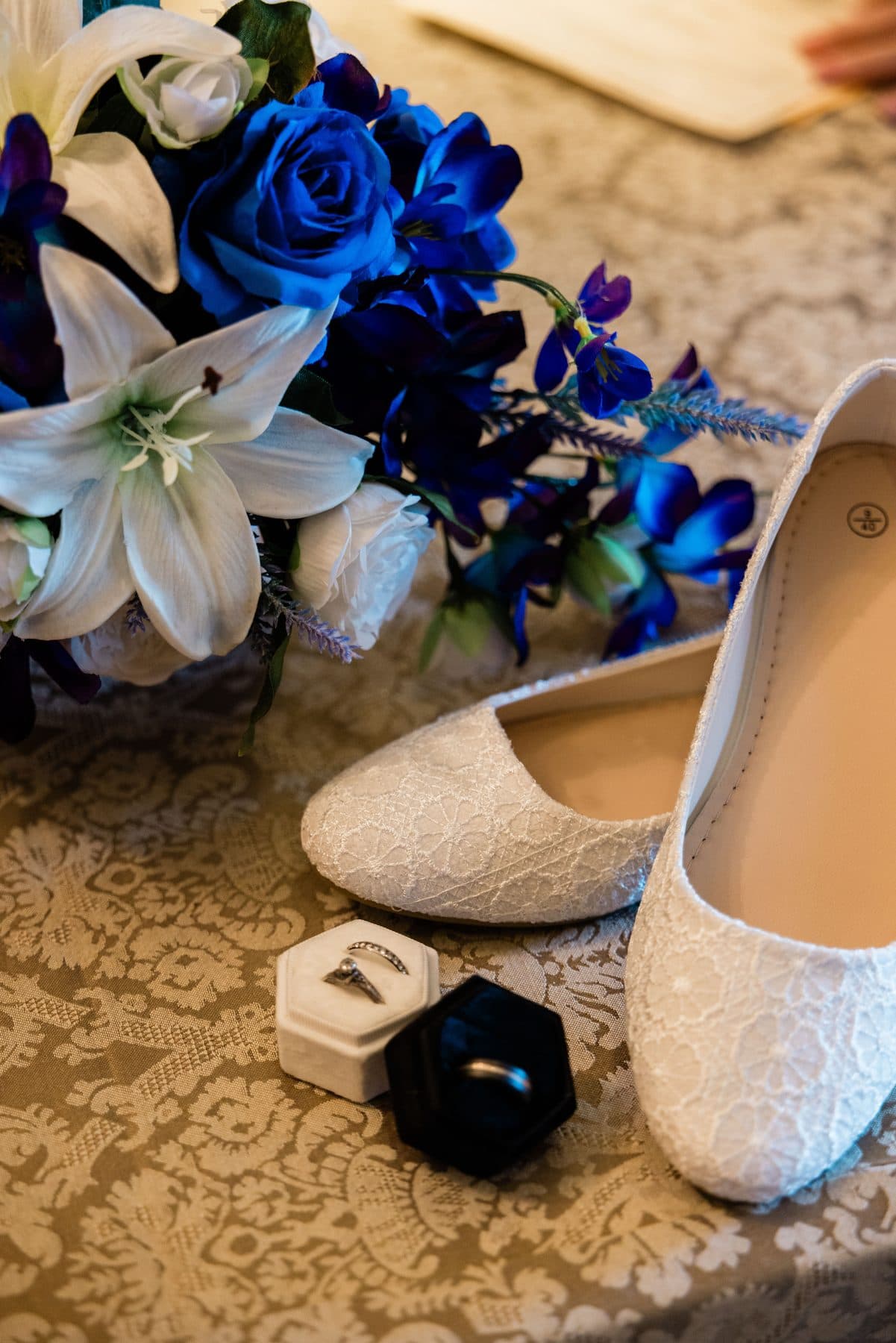 Wedding rings resting beside the bridal bouquet and shoes.